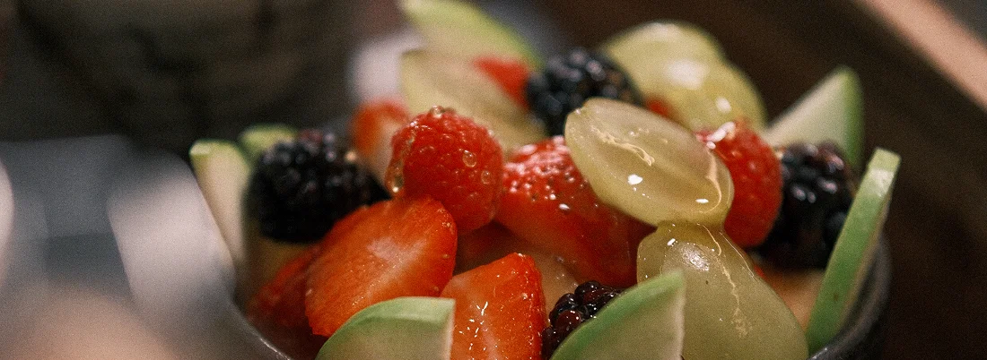 Tazón de fruta fresca con moras, uvas y kiwi